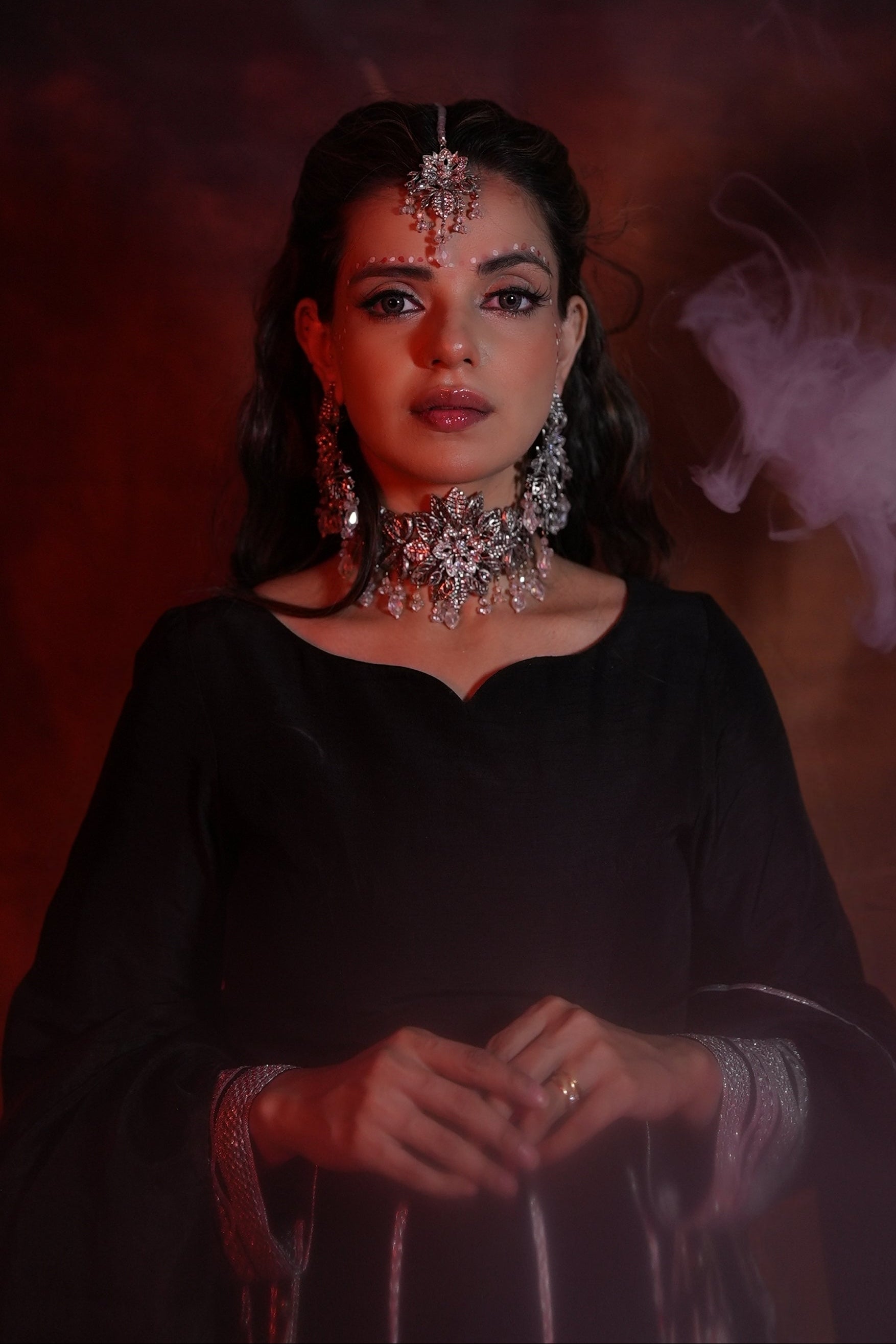 Woman in traditional attire with jewelry against a dark background
