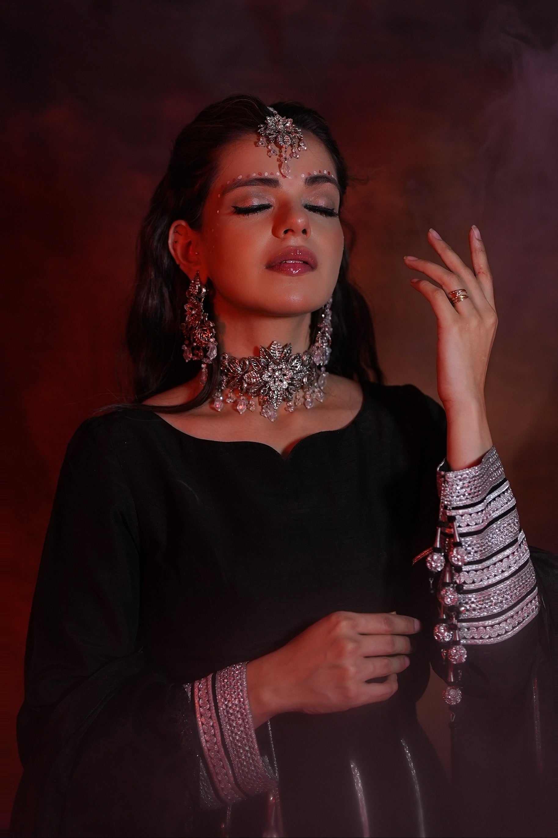 Woman wearing traditional jewelry against a dark background
