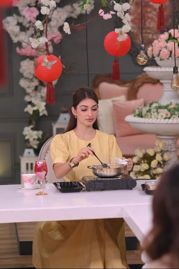 Woman sitting at a table with floral decorations and red lanterns in the background