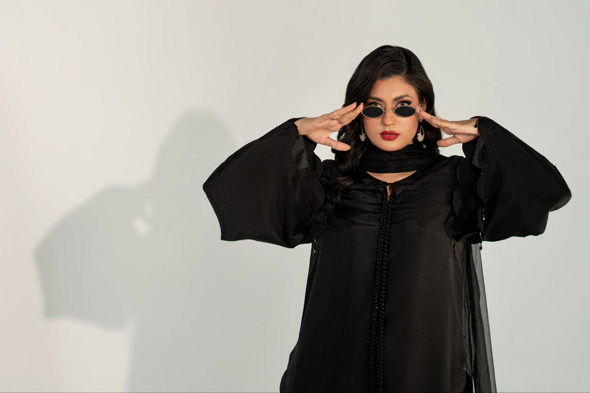 Person wearing a black outfit with a white background