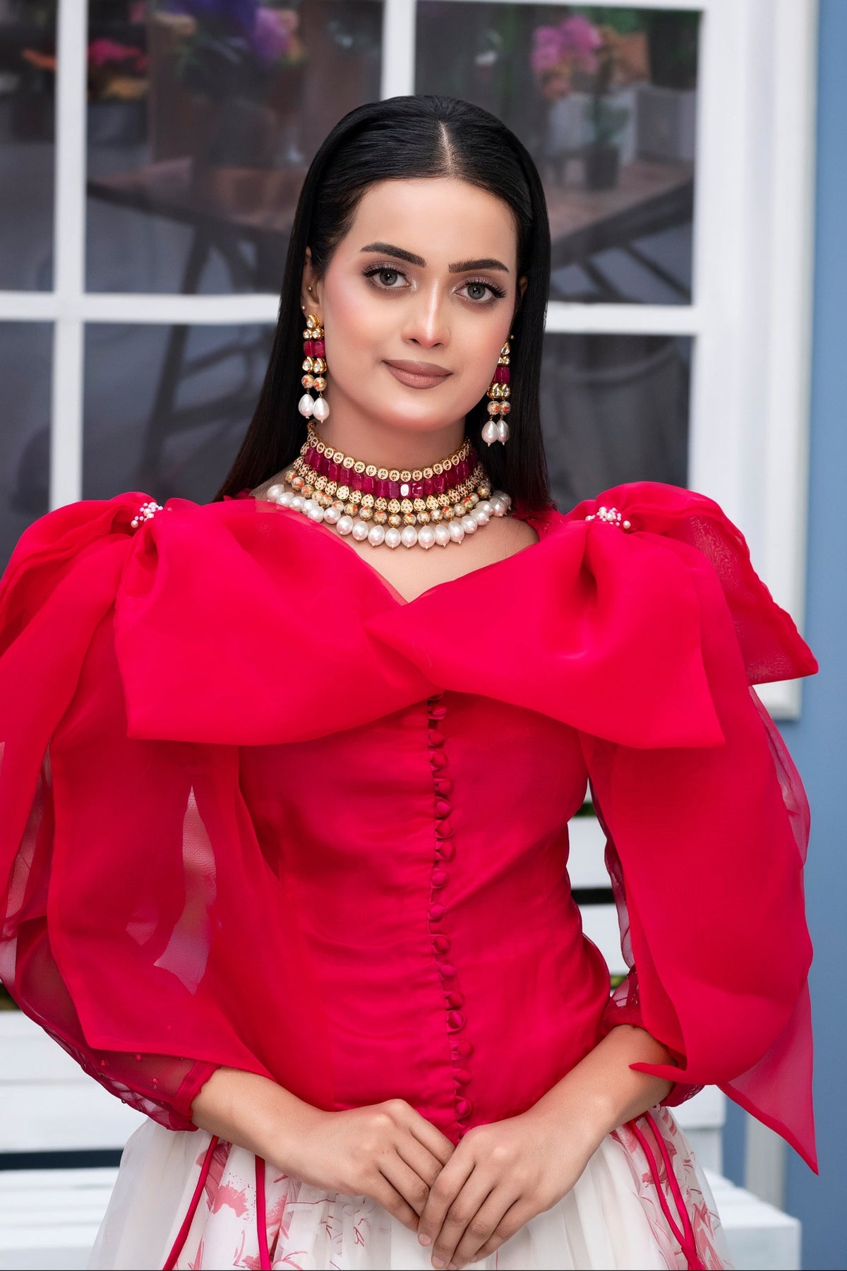 Woman wearing a red traditional outfit with a white background