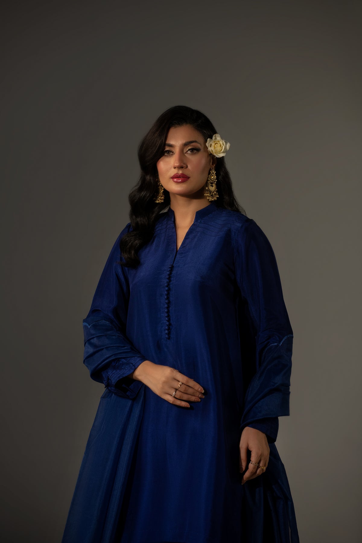Woman wearing a blue dress against a gray background