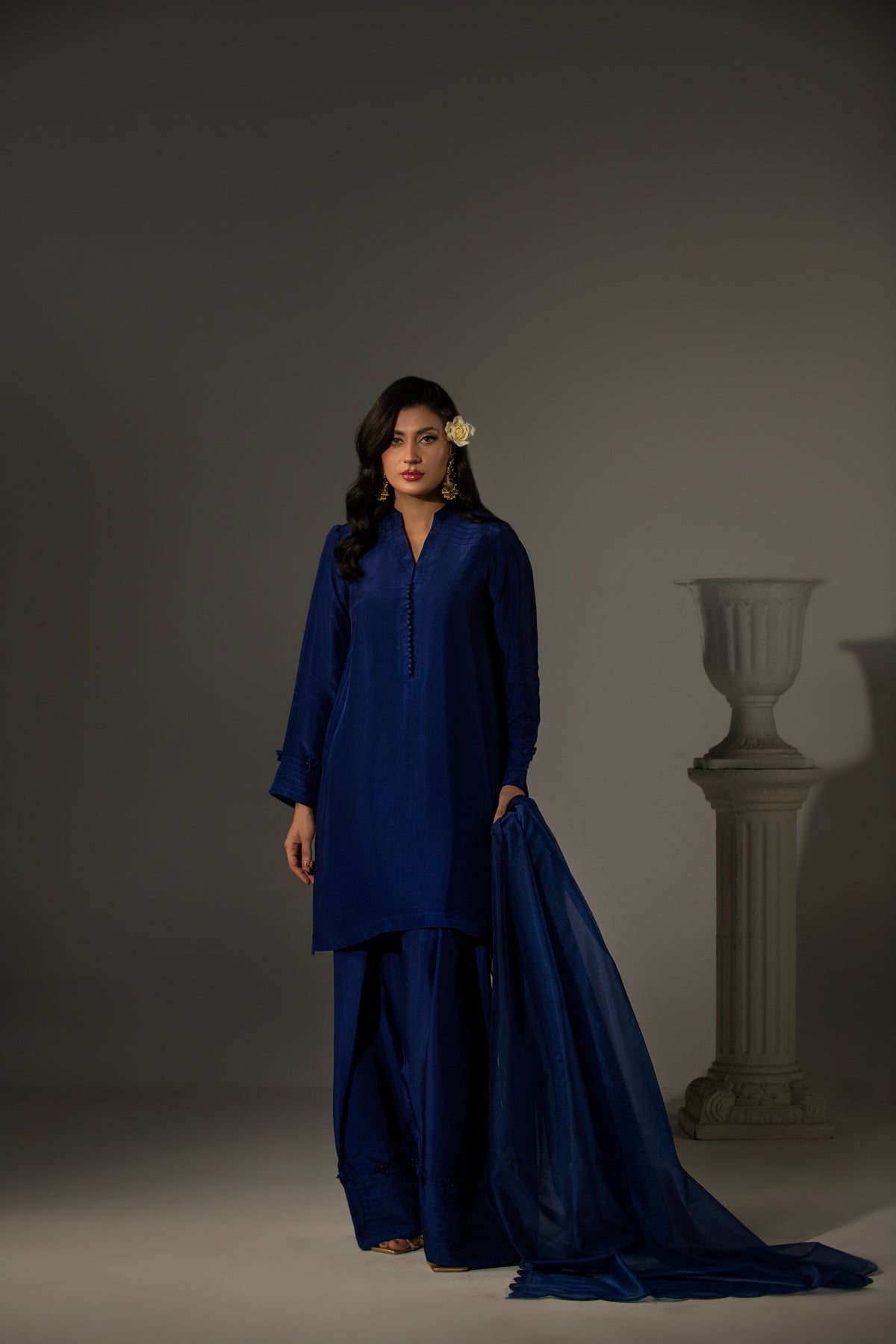 Woman wearing a blue traditional outfit with a gray background
