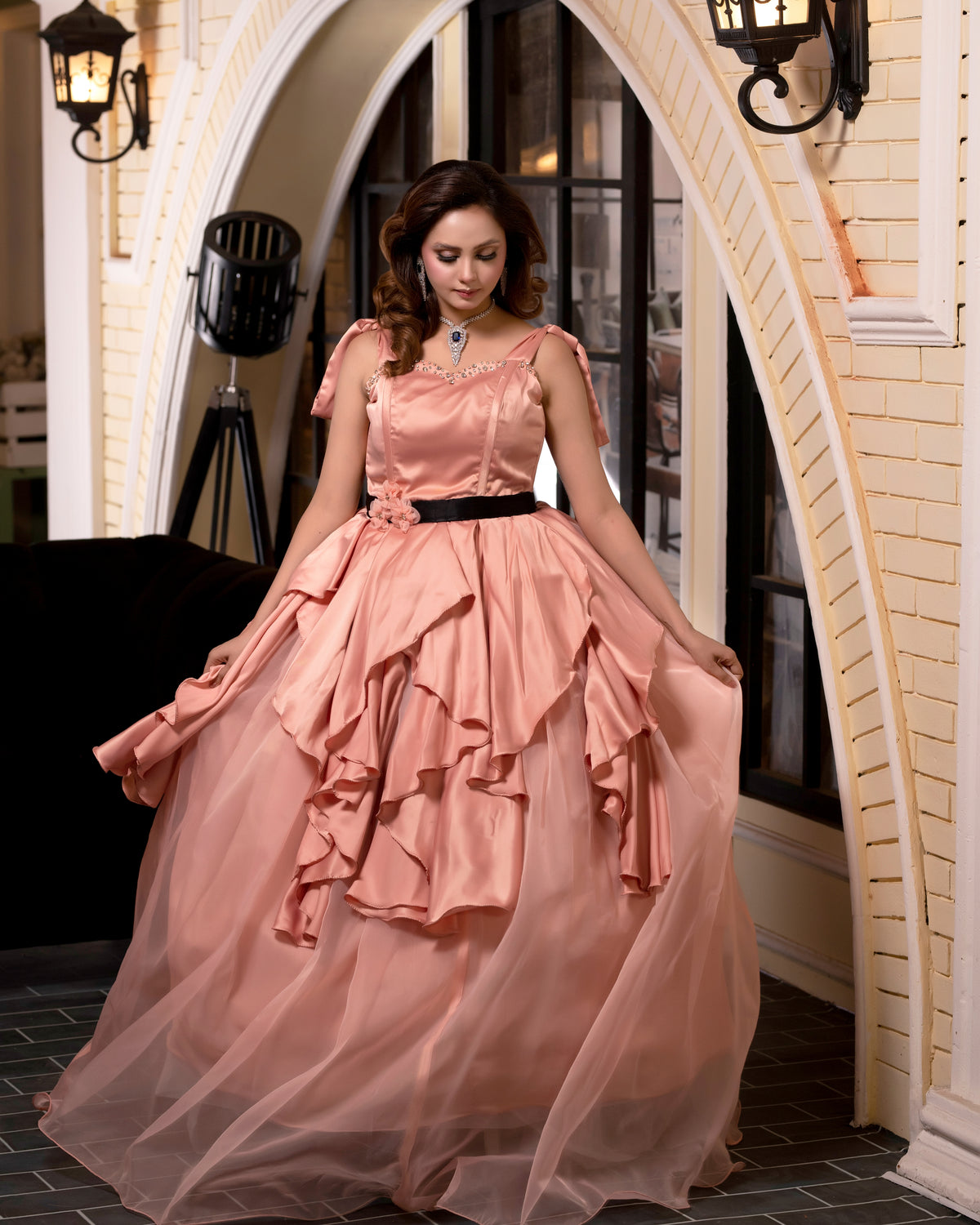 Woman in a pink dress standing in an elegant interior setting