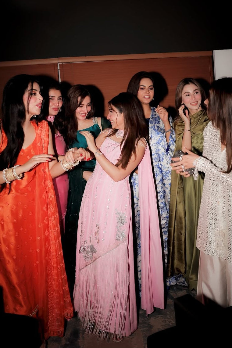 Group of women in traditional attire gathered together indoors.