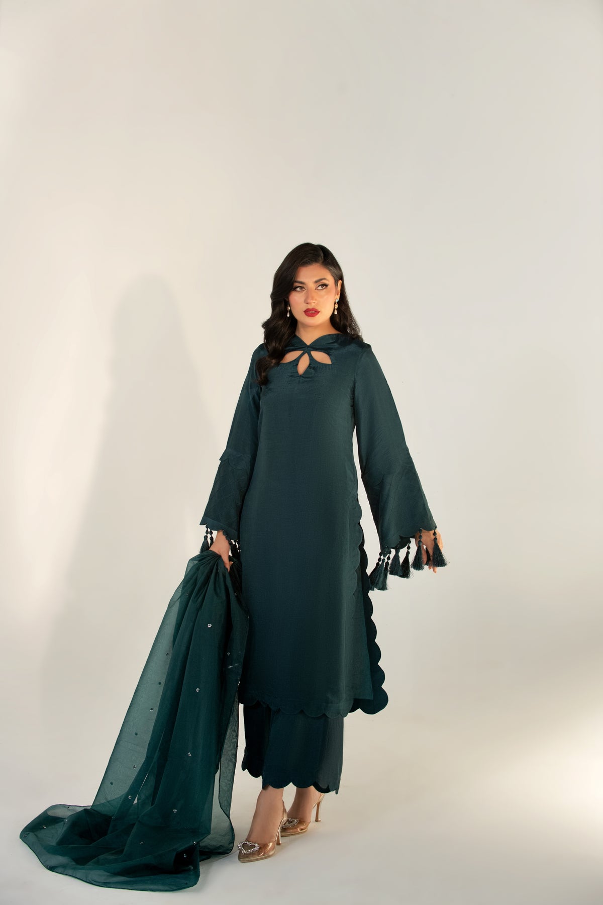 Woman wearing a dark green traditional outfit with a white background