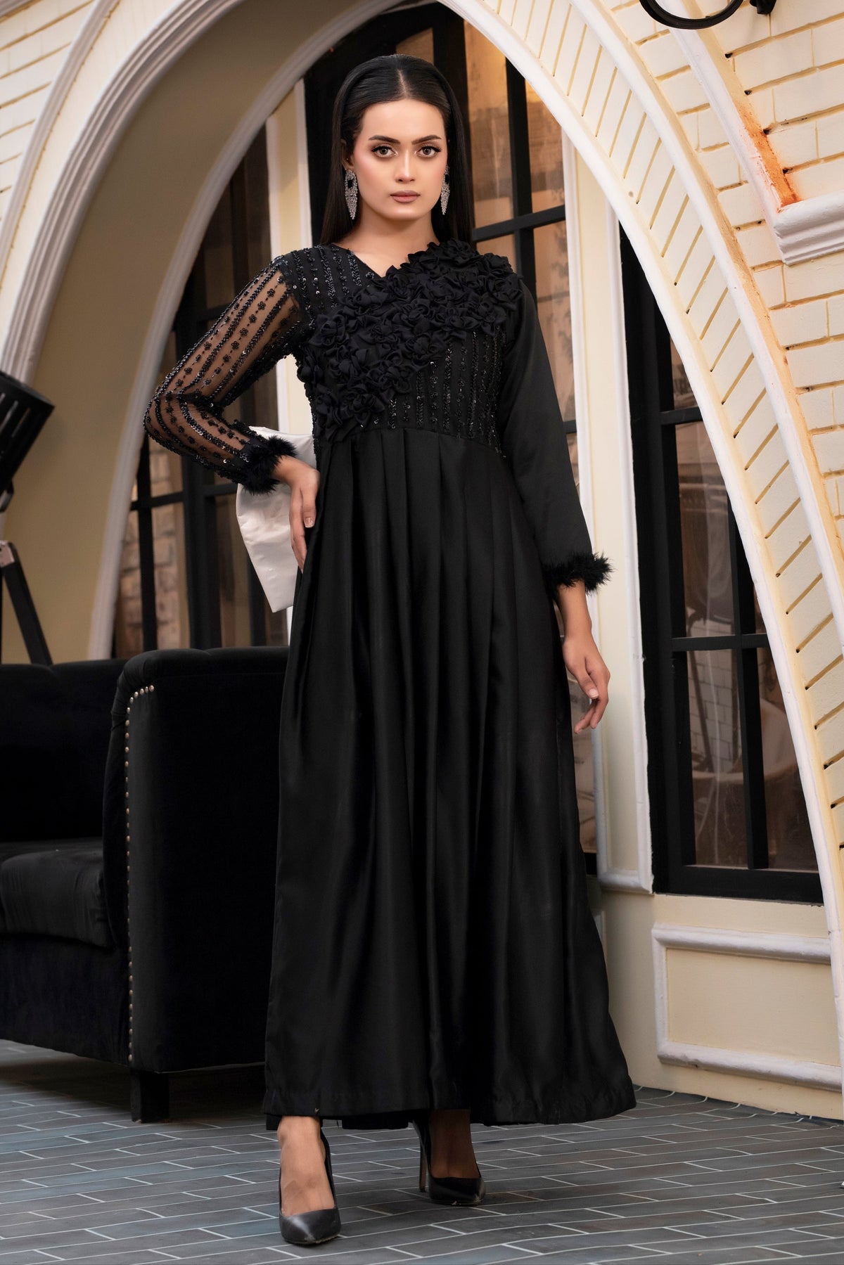 Woman in a black dress standing in an elegant interior setting
