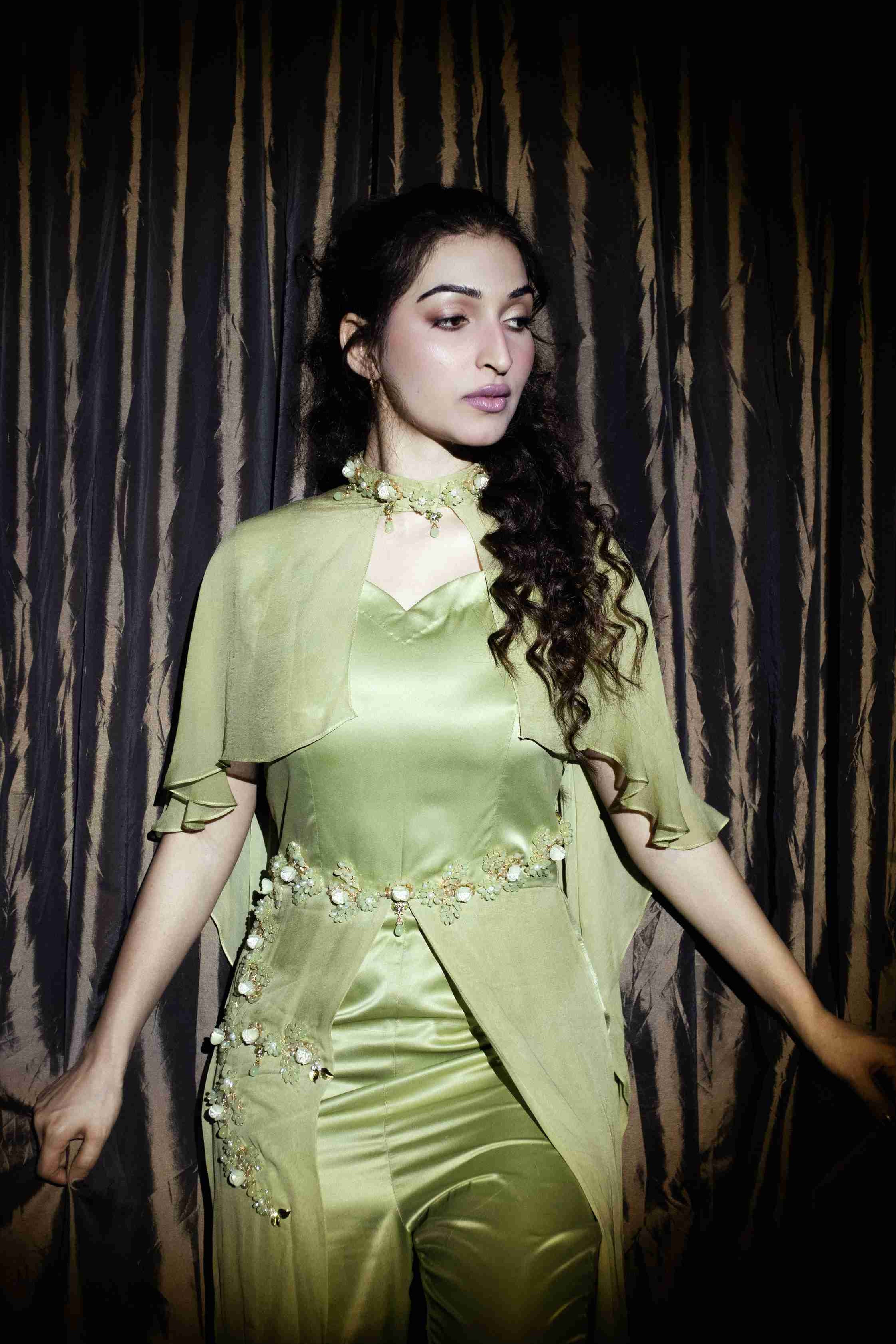 Woman wearing a green outfit with a dark background