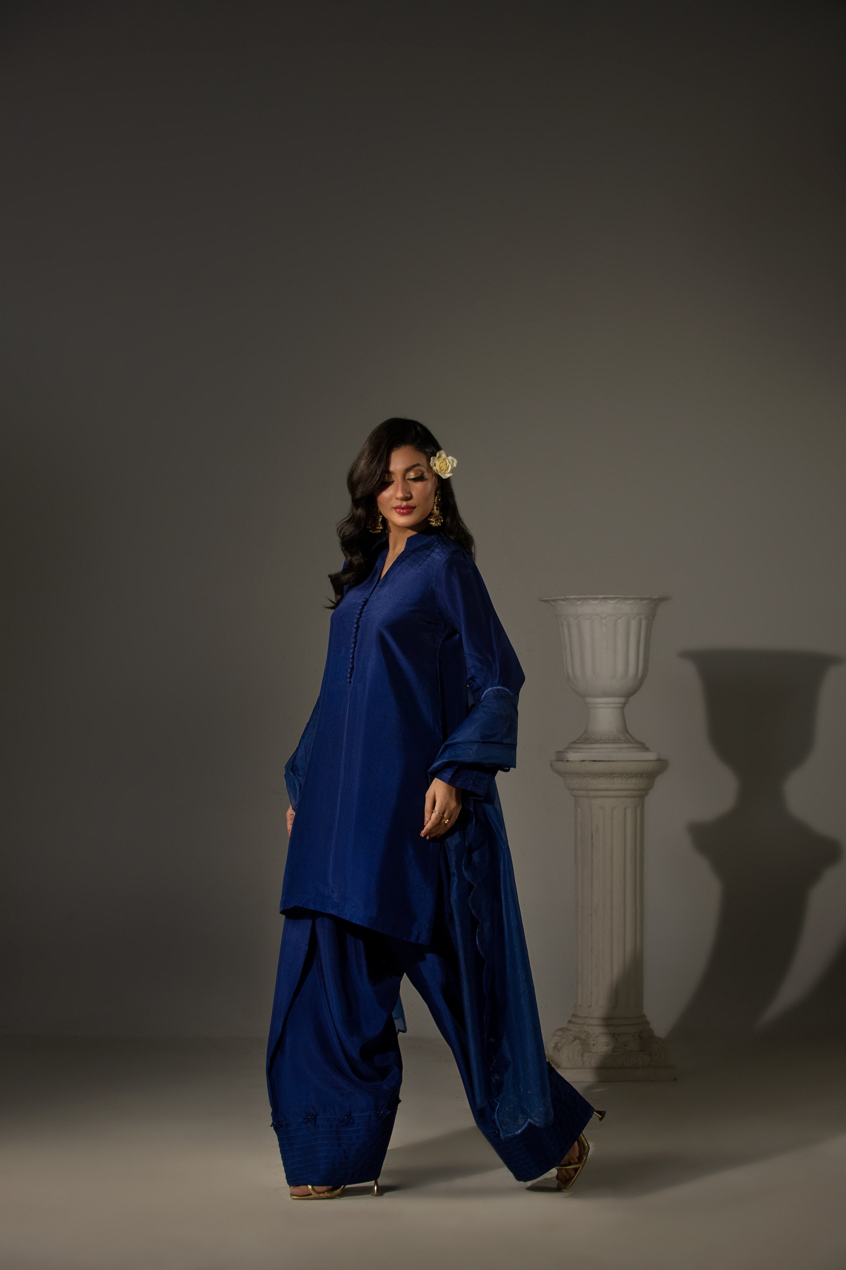 Woman wearing a blue outfit standing against a gray background