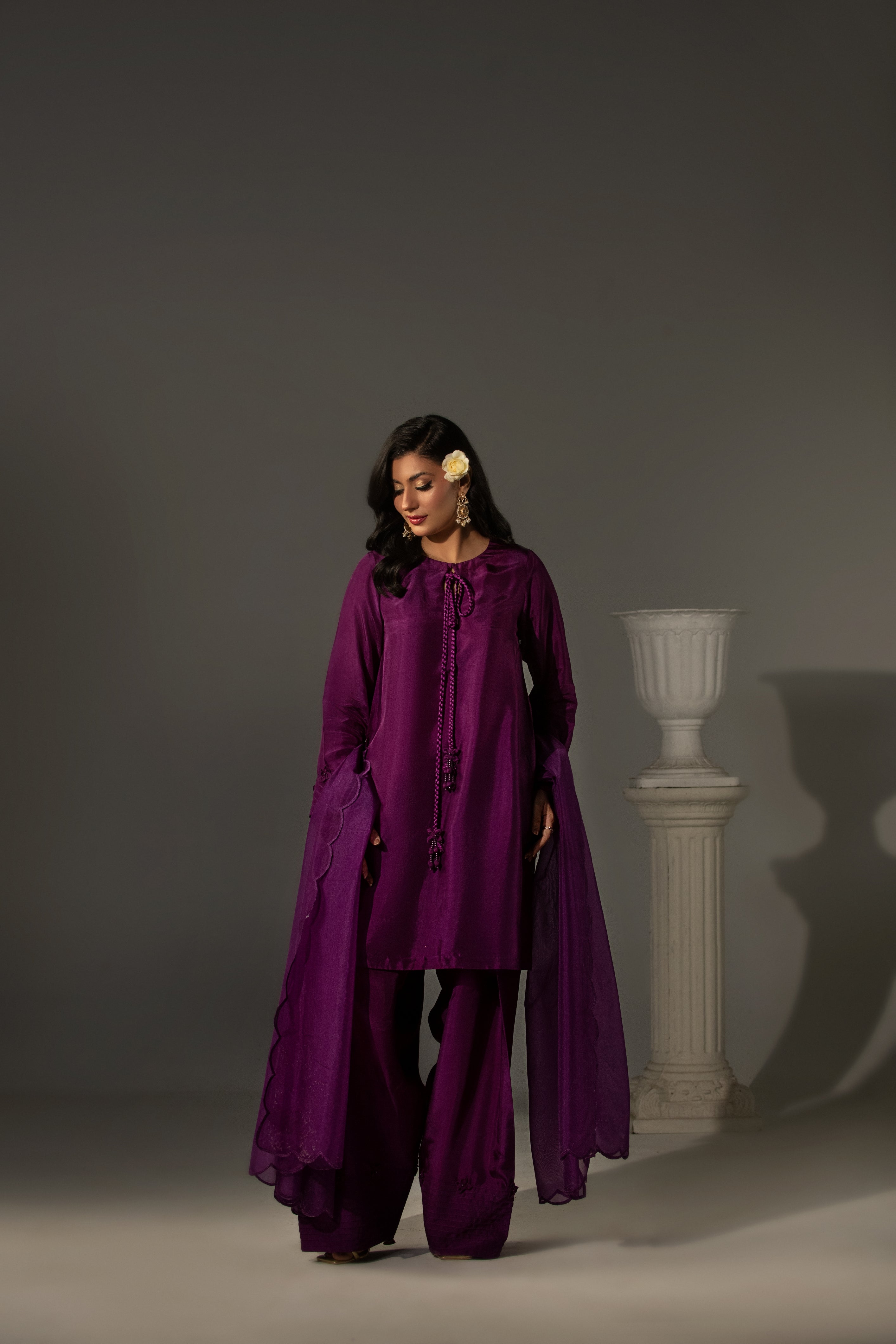 Woman wearing a purple outfit against a gray background