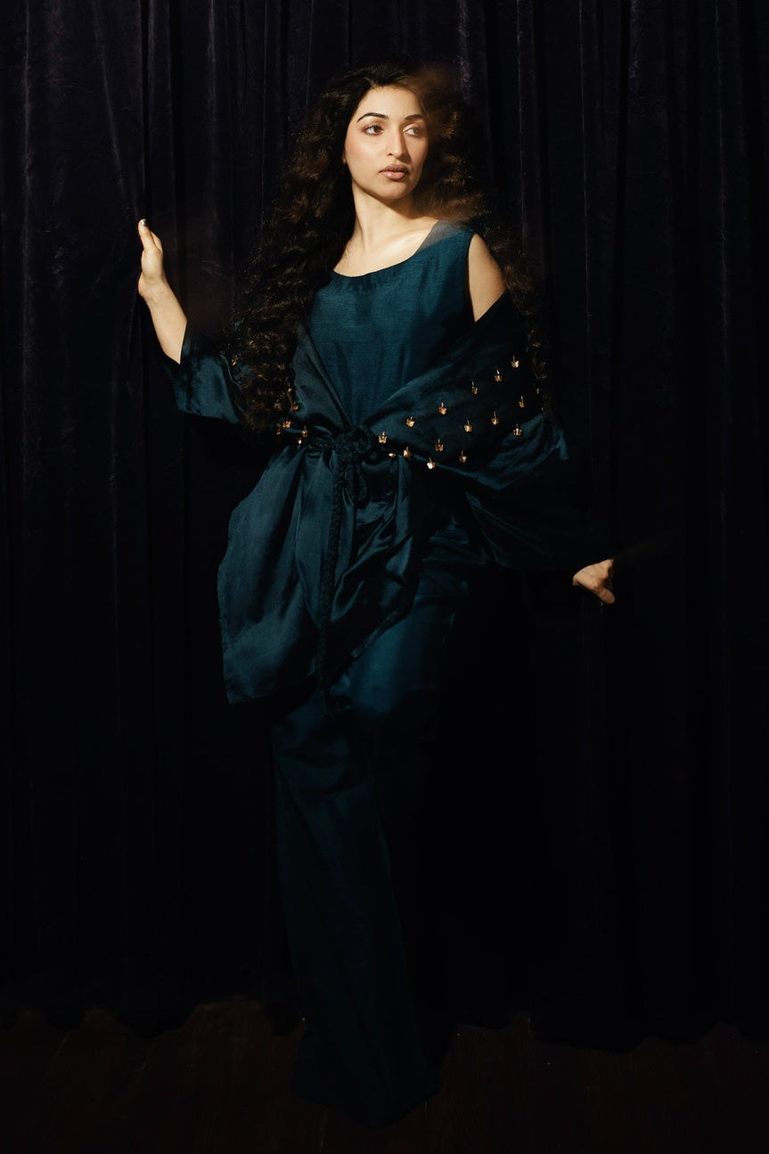 Woman in a teal dress with a black background